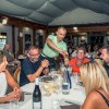 Gruppo di persone ride attorno a un tavolo in un ristorante.