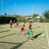 Bambini giocano a calcio su un campo all'aperto.