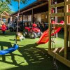 Altalena blu e scivolo rosso in un parco giochi.