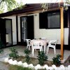 Bungalow con tavolo e sedie all'aperto, piante intorno.