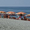 Ombrelloni colorati sulla spiaggia vicino al mare calmo.