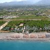 Una spiaggia affollata vista dall'alto, con ombrelloni colorati.