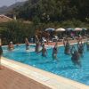 Persone in una piscina seguono un istruttore per una lezione di aerobica.