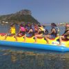Persone su un gonfiabile a forma di banana durante un'attività acquatica.