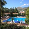 Piscina all'aperto con lettini e ombrelloni.