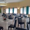Sala da pranzo elegante con tavoli apparecchiati.