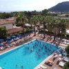 Vista dall'alto di una piscina piena di gente, circondata da lettini.