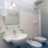 Bagno moderno con lavabo, bidet, doccia, specchio e asciugacapelli.