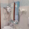 Un bagno moderno con asciugacapelli, specchio, lavandino e mosaici blu sulle pareti.