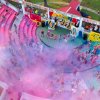 Evento colorato all'aperto con molte persone e polveri colorate sollevate.