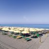 Spiaggia con ombrelloni gialli allineati.