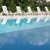 Sedie a sdraio bianche vicino a una piscina.