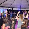 Persone che ballano sotto un grande gazebo illuminato.