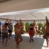 Persone che fanno yoga su una terrazza all'aperto.