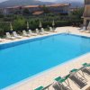 Piscina all'aperto con lettini e ombrelloni bianchi.