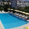 Piscina circondata da lettini e ombrelloni gialli e bianchi.