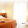 Camera da letto con letto matrimoniale e luci soffuse.