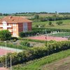 Campi sportivi e edificio in un paesaggio verde.