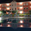Edificio illuminato con sedie a sdraio riflesso in una piscina.