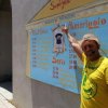 Persona davanti a un cartellone con programma giornaliero.