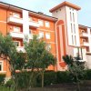 Edificio arancione con balconi e giardino.