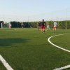 Persone giocano a calcio su un campo erboso.