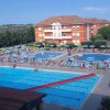 Piscina all'aperto con lettini e ombrelloni.