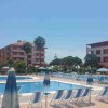Piscina con sedie e ombrelloni chiusi in un hotel.