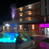 Fontana illuminata di notte davanti a un edificio.