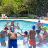 Bambini giocano con l'acqua in piscina.