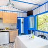Cucina semplice con pareti blu e finestra aperta.