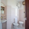 Un bagno bianco con bidet, toilette e lavandino.