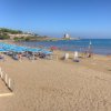 Una spiaggia sabbiosa con ombrelloni e persone al mare.