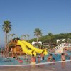Piscina con scivoli gialli e persone che si divertono.