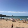 Una spiaggia affollata con bagnanti e ombrelloni.
