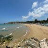 Spiaggia sabbiosa con mare calmo.
