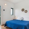 Camera da letto con letto matrimoniale blu, lampade su comodini e porta aperta su balcone.