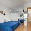 Camera da letto con letto matrimoniale e singolo blu, bagno a vista.