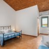 Camera spaziosa con letto matrimoniale in ferro, pavimento in legno e vista sul mare.