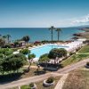 Piscina vicino al mare con palme.