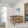 Trilocale standard con mobili in legno, letto blu e tavolo da pranzo.