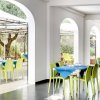 Sala interna con tavoli apparecchiati e sedie verdi.