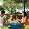 Famiglia che pranza all'aperto vicino alla piscina.