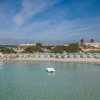 Spiaggia con ombrelloni azzurri e mare cristallino.