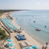 Spiaggia con sdraio e ombrelloni.