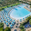 Piscina con molti ombrelloni azzurri.